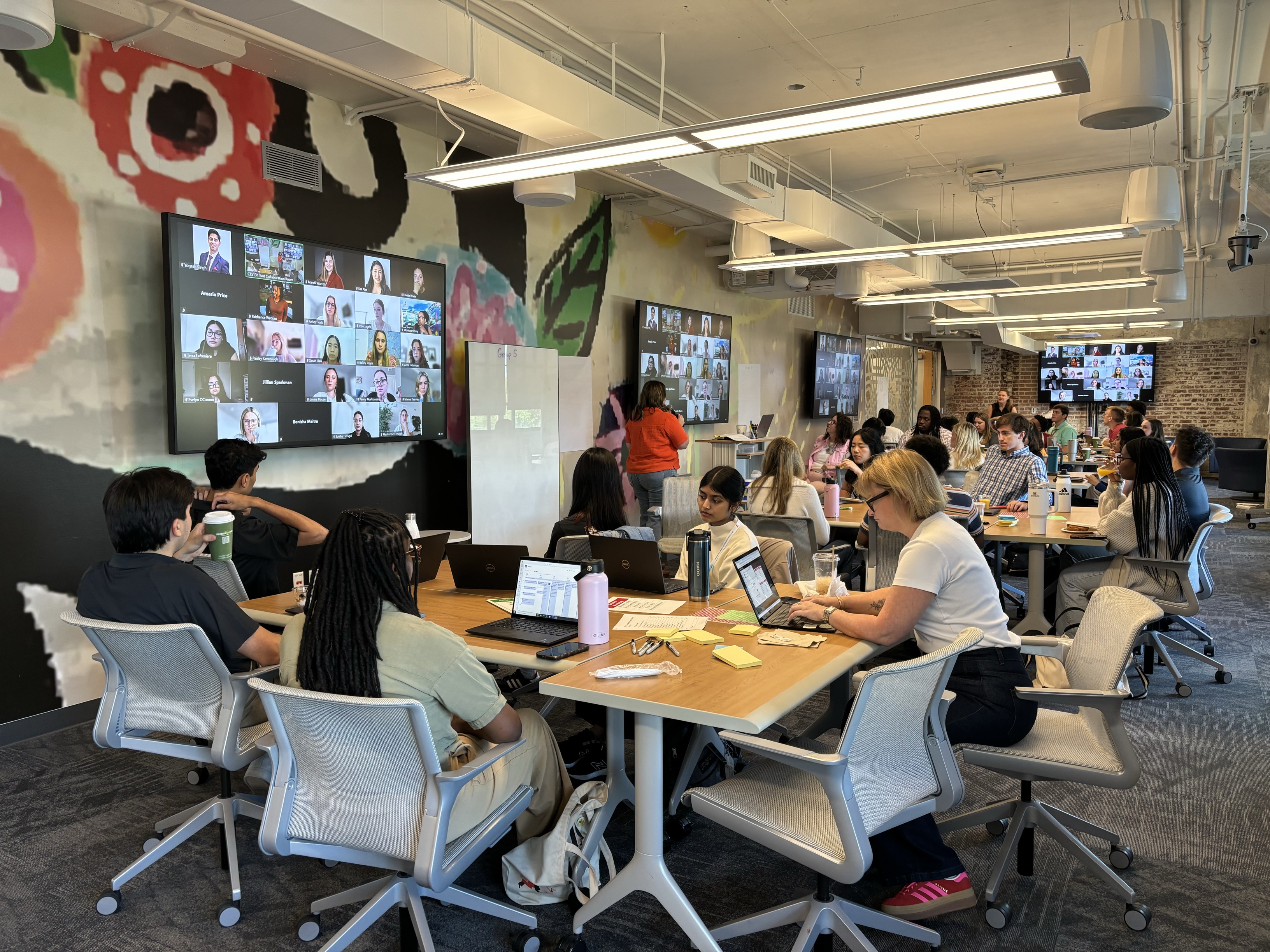Image showing virtual and in-person people collaborating in a meeting room.